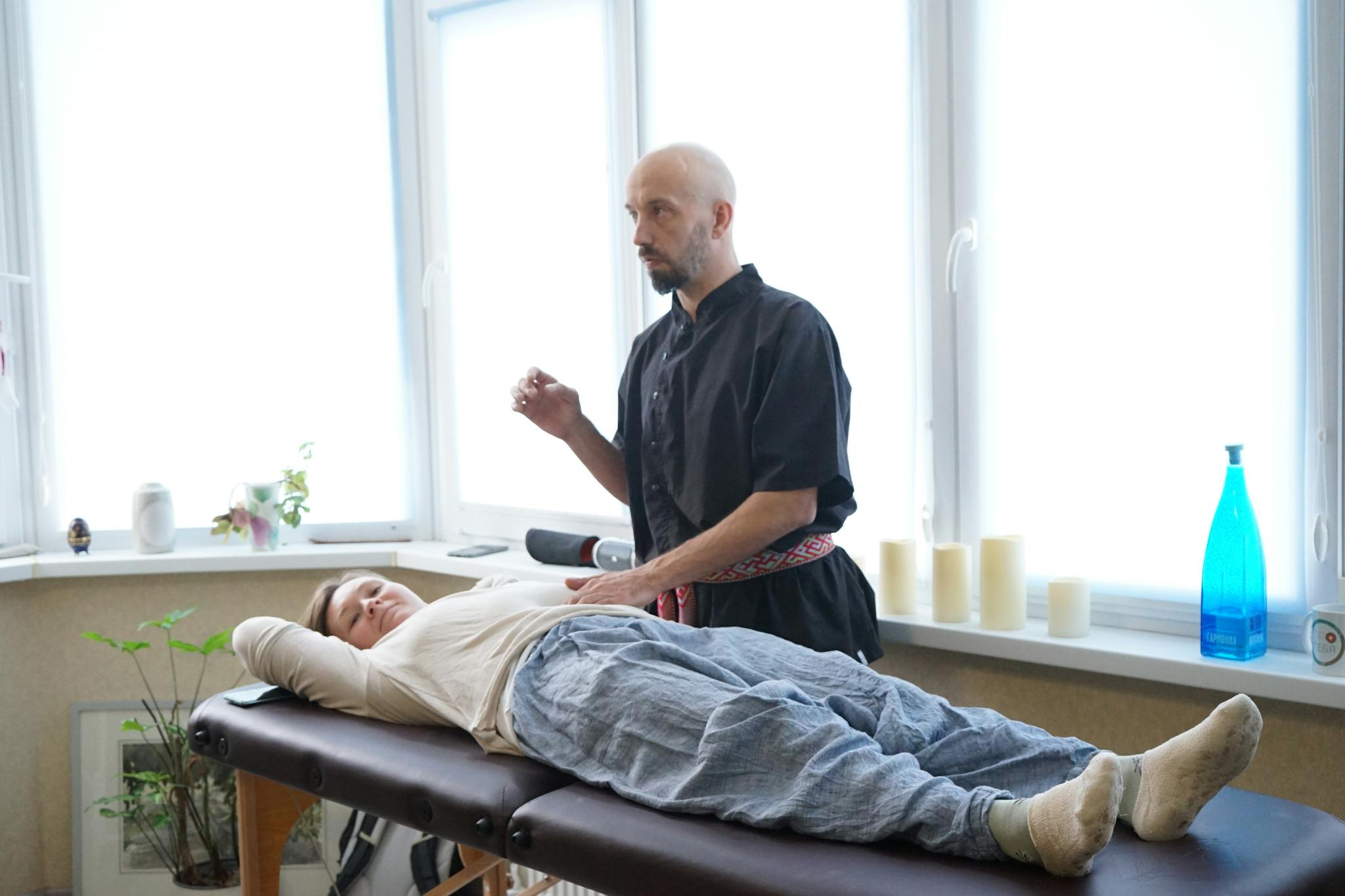 A masseur performing a therapeutic massage on a woman in a relaxing spa setting, promoting wellness.